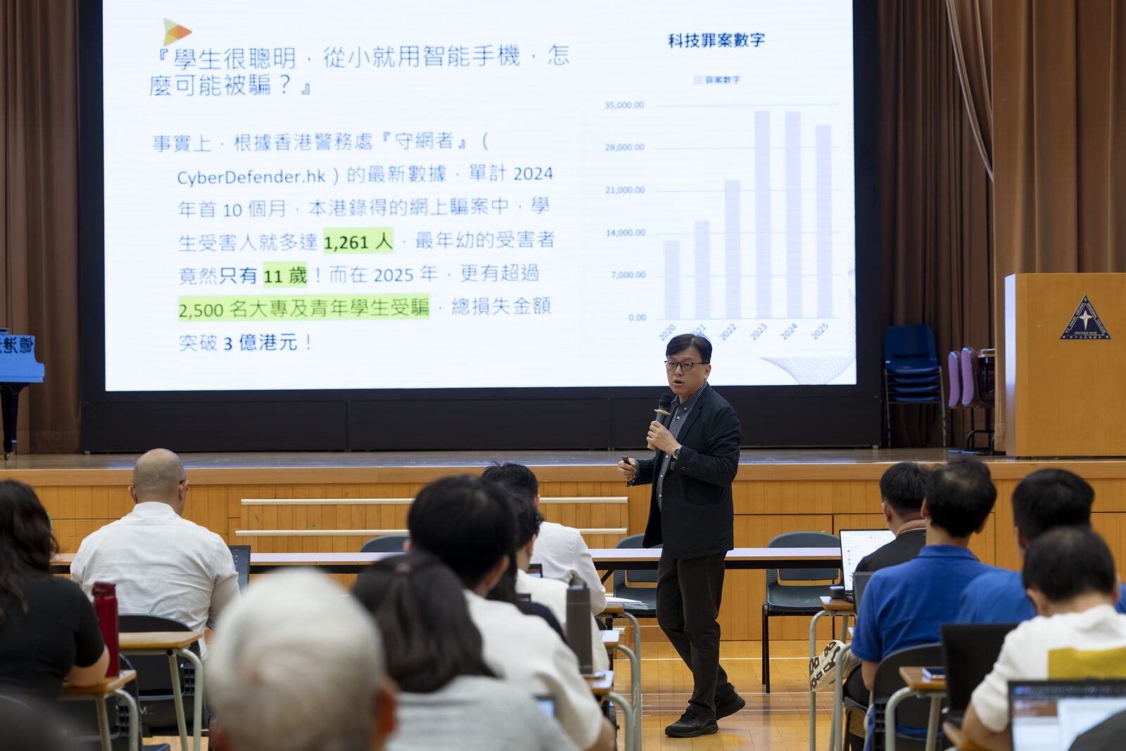 魏遠強先生於余振強紀念中學主講台上,講解學生常遇的網絡詐騙趨勢。